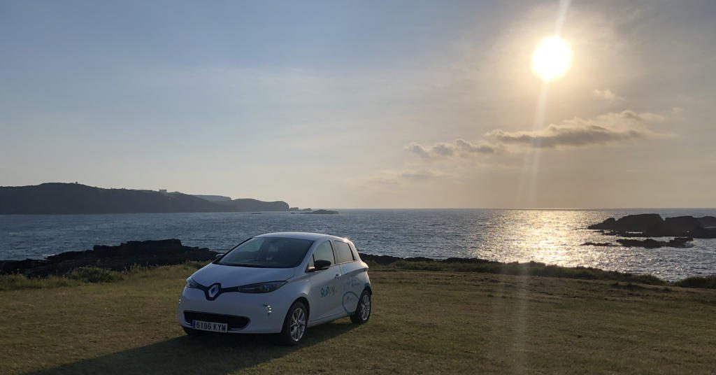 coche eletrico se carga con energia solar estacionado en un precioso paisaje en un día de sol